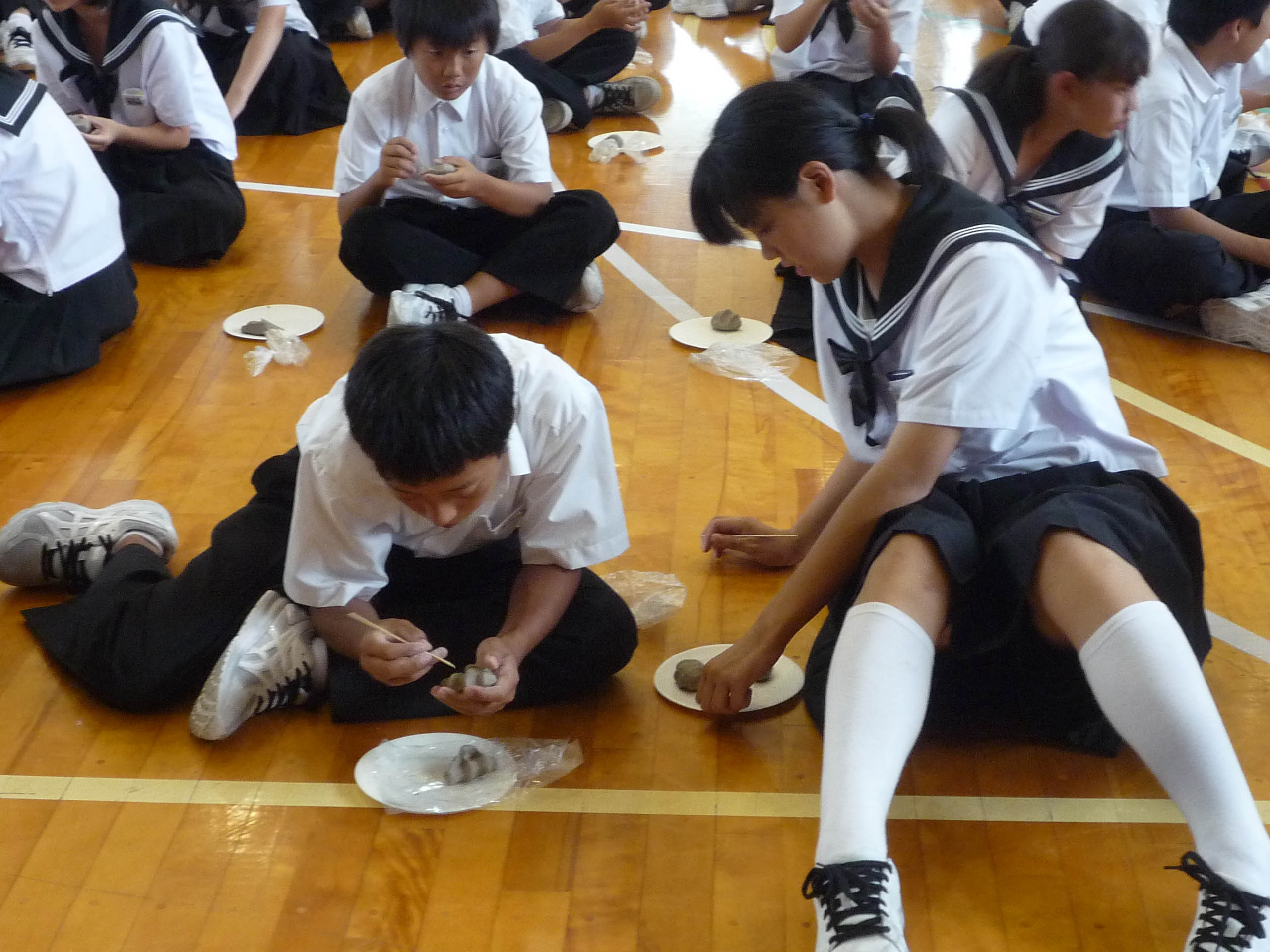 土のオブジェを仕上げる生徒たち